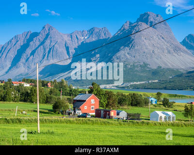 Bauernhof Häuser südlich von svensby am Kjosenfjord, Aussicht über den Fluss, steilen Berggipfeln der Halbinsel Lyngen, Norwegen Stockfoto