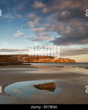 Am frühen Morgen Sonnenlicht beleuchtet Robin Hood's Bay von boggle Loch auf der North Yorkshire Küste in der Nähe von Whitby. Stockfoto