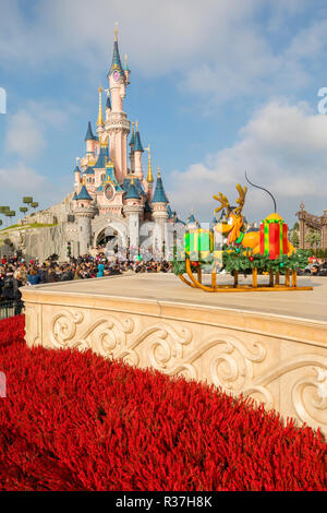 Disneyland Paris, Frankreich, November 2018: Dornröschen Schloss mit blauen Himmel hinter und roten Blüten vor Stockfoto