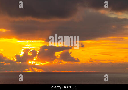 Sonnenaufgang oder Sonnenuntergang durch Gewitterwolken über den Atlantik Stockfoto