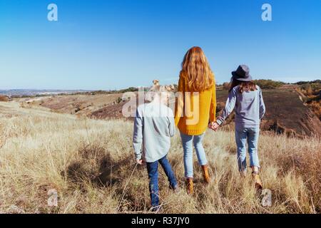 Glückliche Familie - Mutter und zwei Töchtern zu Fuß auf einer Wiese im Herbst Stockfoto