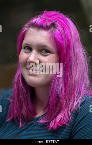 Porträt einer jungen Frau mit Sommersprossen und rosa, violett gefärbte Haare, Deutschland Stockfoto