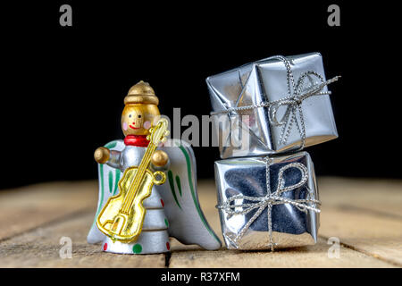 Weihnachtsschmuck auf dem Küchentisch. Holz- Weihnachten figuren vorbereitet für die Verzierung eines Baumes. Der dunkle Hintergrund. Stockfoto