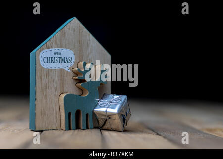 Weihnachtsschmuck auf dem Küchentisch. Holz- Weihnachten figuren vorbereitet für die Verzierung eines Baumes. Der dunkle Hintergrund. Stockfoto