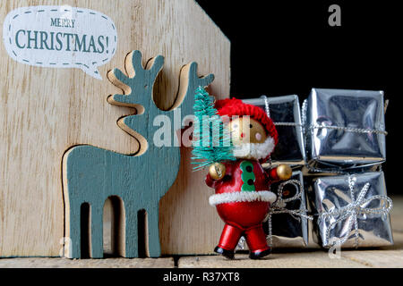 Weihnachtsschmuck auf dem Küchentisch. Holz- Weihnachten figuren vorbereitet für die Verzierung eines Baumes. Der dunkle Hintergrund. Stockfoto