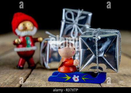 Weihnachtsschmuck auf dem Küchentisch. Holz- Weihnachten figuren vorbereitet für die Verzierung eines Baumes. Der dunkle Hintergrund. Stockfoto