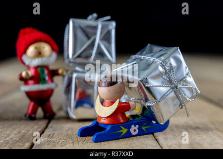 Weihnachtsschmuck auf dem Küchentisch. Holz- Weihnachten figuren vorbereitet für die Verzierung eines Baumes. Der dunkle Hintergrund. Stockfoto