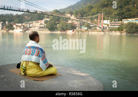 Ein Mönch meditieren Neben den heiligen Ganges. Rishikesh, Indien Stockfoto