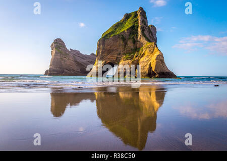 Wharariki Beach, Neuseeland: wunderschöne Felsformationen widerspiegeln, im Wasser als mächtige Wellen Kampf gegen das Ufer. Diese weite Strecke der Küste displ Stockfoto