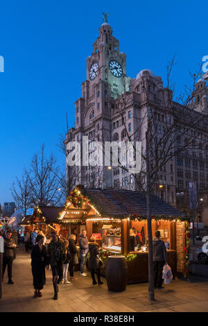 Weihnachtsmarkt Stände auf dem Weihnachtsmarkt Ice Festival Messegelände mit der Leber Gebäude hinter, Pier Head, Liverpool, England, UK Stockfoto