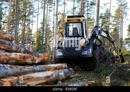 Salo, Finnland - 18. November 2018: Logging site im finnischen Wald an einem Tag im Herbst mit Logs stack und harvester Ponsse Ergo Wald. Stockfoto