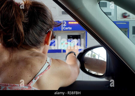 Languedoc-Roussillon, Frankreich - 28. Juli 2018: eine Frau Zahlung mit Kreditkarte an die automatische unbemannte Mautstelle oder Peage auf einer französischen Autobahn oder m Stockfoto