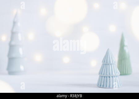 Keramik Spielzeug Weihnachtsbaum Statuetten mit Girlande bokeh auf Hintergrund, geringe Tiefenschärfe. Stockfoto