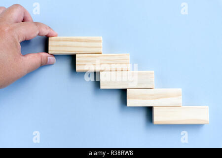 Das Konzept der Vermittlung von holzklotz Stapeln wie Schritt Treppe. Stockfoto