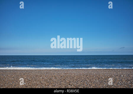 Kieselstrand mit keine Leute an der Lehm auf Meer mit großen blauen Himmel und kleine Menge Meer Stockfoto