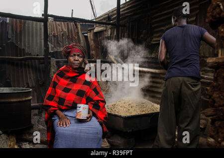 Kenia. 11 Nov, 2018. Ein Mann wird gesehen, Rösten sorghum Mischung, um den Alkohol in Kibera zu brauen. Für eine lange Zeit, die meisten Frauen aus Kibera Slums haben unter dem Einfluss von Alkohol. Nicht angesichts der Nebenwirkungen, Frauen hier ist aus verschiedenen Gründen einschließlich der Übernahme von Stress und über ihre Probleme in der Familie zu Hause zu vergessen. Dies ist wegen des Mangels an genügend Beschäftigungsmöglichkeiten und Unterstützung von ihren Ehemännern. Der hohe Alkoholkonsum hat zu einer höheren Rate von Todesfällen, Blindheit geführt, und das Risiko für viele gefährliche Krankheiten wie Krebs, Bluthochdruck, strok Stockfoto