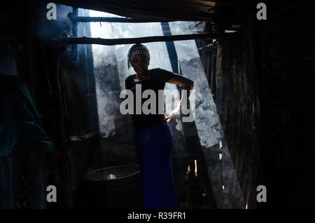 Kenia. 16 Nov, 2018. Eine Frau gesehen steht neben einem Eimer mit lokalen gebraut Alkohol in der Bar in Kibera. Für eine lange Zeit, die meisten Frauen aus Kibera Slums haben unter dem Einfluss von Alkohol. Nicht angesichts der Nebenwirkungen, Frauen hier ist aus verschiedenen Gründen einschließlich der Übernahme von Stress und über ihre Probleme in der Familie zu Hause zu vergessen. Dies ist wegen des Mangels an genügend Beschäftigungsmöglichkeiten und Unterstützung von ihren Ehemännern. Der hohe Alkoholkonsum hat zu einer höheren Rate von Todesfällen, Blindheit geführt, und das Risiko für viele gefährliche Krankheiten wie Krebs, hyperte Stockfoto