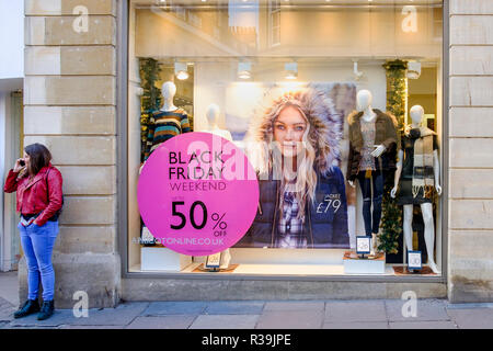 Badewanne, Großbritannien. 22. November 2018. Mit schwarzer Freitag Umsatz aufgrund am Freitag zu starten, ist eine Frau abgebildet, die sich in Ihr Telefon vor einem Schaufenster im Zentrum von Bath, UK. Credit: Lynchpics/Alamy leben Nachrichten Stockfoto