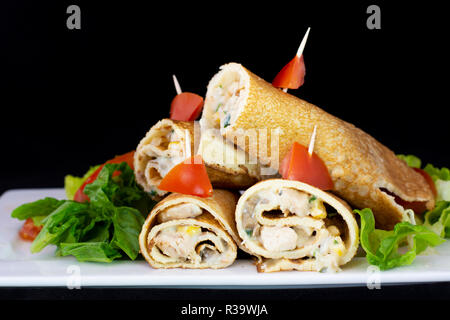 Huhn Pfannkuchen mit Salat innen mit isolierten schwarzen Hintergrund Stockfoto