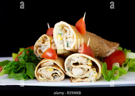 Huhn Pfannkuchen mit Salat innen mit isolierten schwarzen Hintergrund Stockfoto