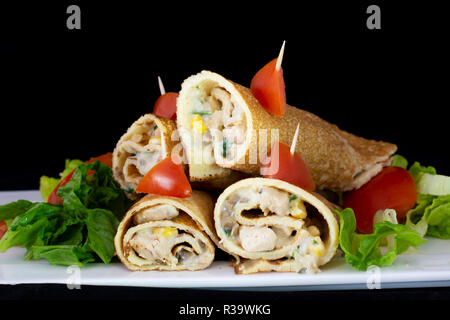 Huhn Pfannkuchen mit Salat innen mit isolierten schwarzen Hintergrund Stockfoto