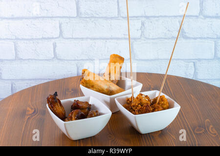 Hausgemachten köstlichen Frühlingsrollen mit Sweet und kalten Saucen auf Holz Tisch serviert Stockfoto