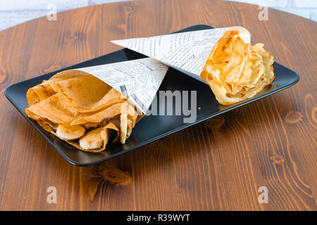 Lecker Banane Crepe mit Schokolade Dressing auf Holz Tisch Stockfoto