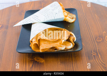 Lecker Banane Crepe mit Schokolade Dressing auf Holz Tisch Stockfoto