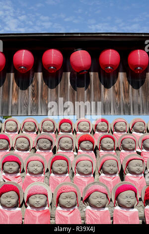 Reihe von buddhistischen jizo mizuko Statuen mit roten Latz, Hut, Schal Stockfoto