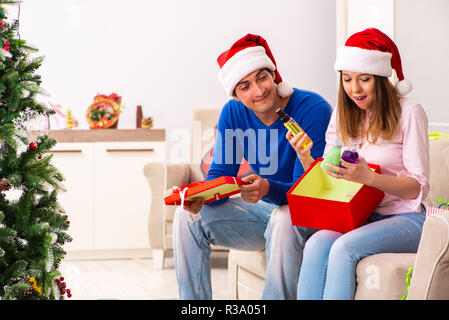 Junges Paar Weihnachten zu Hause feiern. Stockfoto