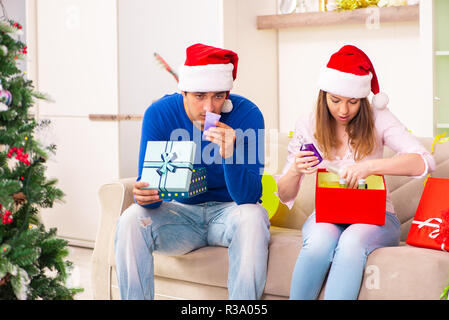 Junges Paar Weihnachten zu Hause feiern. Stockfoto