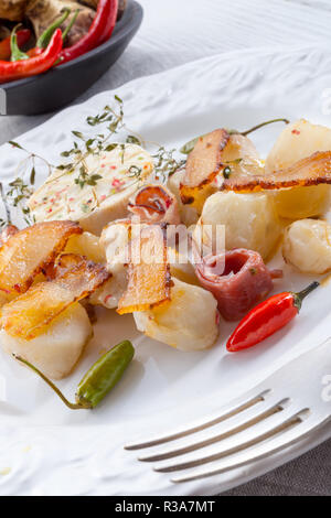 Topinambur gratiniert mit Schinken und Chili Stockfoto