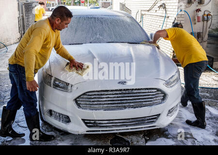 Miami Florida, Little Havana, Autowaschanlage, weißer Ford Fusion, hispanischer Mann Männer männlich, arbeiten, putzen, Seifenspülung wischen, Teamarbeit, FL181115002 Stockfoto