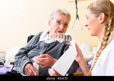 Krankenschwester interessiert sich für Senioren im Altenheim Stockfoto