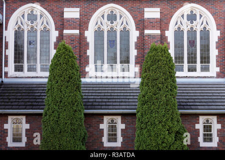 Neo-gotischen Stil windows und roten Backsteinfassade von St. Augustine's Gemeinde Katholische Kirche in Kitsilano, Vancouver, BC, Kanada Stockfoto