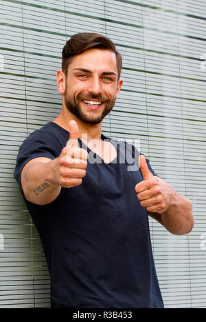 Junger Mann mit zwei Daumen hoch Stockfoto