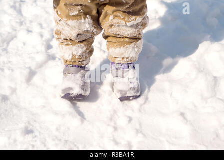 In der Nähe von Babys Füße im Winter Stiefel mit Schnee bedeckt Stockfoto