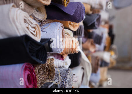 Stoff gefaltet mit Rollen in verschiedenen Farben übereinander gefaltet Stockfoto