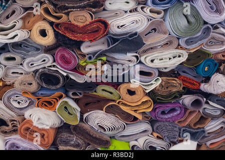 Stoff gefaltet mit Rollen in verschiedenen Farben übereinander gefaltet Stockfoto