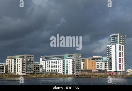 Cardiff Bay Apartments unter späten Nachmittag Sonne, mit einem dunklen und bedrohlichen Himmel hinter. Perfektes Licht für diese Art von Foto. Stockfoto