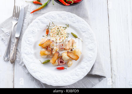 Topinambur gratiniert mit Schinken und Chili Stockfoto