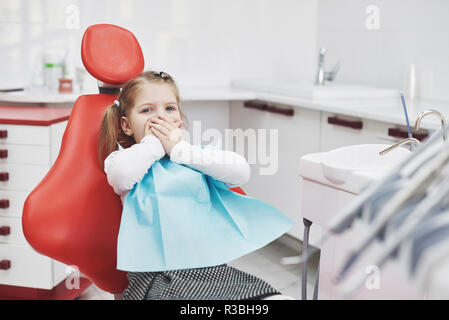 Kleines Mädchen an Zahnarzt Mund mit Händen bedeckt Angst Stockfoto