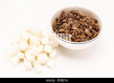 Weiße Zuckerwürfel mit braunem Zucker in einer weißen Schüssel Stockfoto