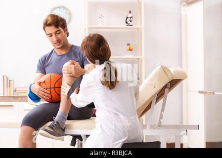 Stattliche Basketballspieler besuchen Ärztin traumatologist Stockfoto