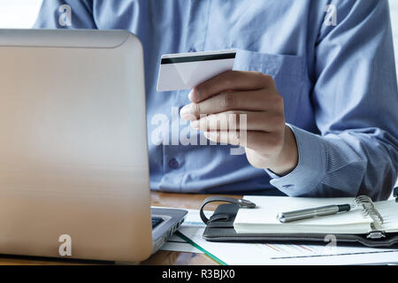 Unternehmer, die Kreditkarte und mit Laptop. Die Zahlung beim Online shopping. E-Commerce und moderne Technik Konzept Stockfoto