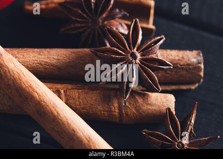 Anis Sterne Gewürze und Zimtstangen auf dunklen rystic Holz- Hintergrund, Nahaufnahme, Makro. Stockfoto