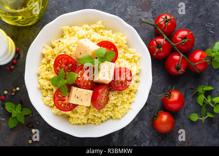 Millet Porridge mit Tomaten und Käse Stockfoto