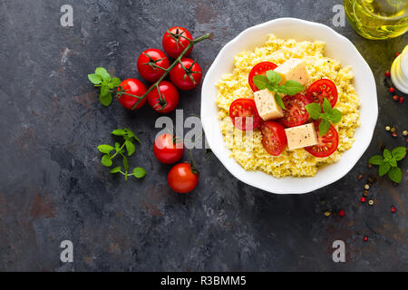 Millet Porridge mit Tomaten und Käse Stockfoto