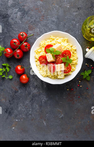 Millet Porridge mit Tomaten und Käse Stockfoto