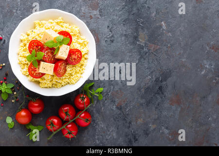 Millet Porridge mit Tomaten und Käse Stockfoto